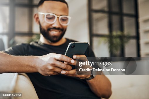 Glücklicher Mann, Social-Media-Telefon und Wohnzimmer entspannen, Smartphone und Online-Kommunikation tippen, Benachrichtigung lesen und Web auf dem Sofa. Smile Guy Hände, mobile Verbindung und Heimnetzwerktechnologie Glücklicher Mann, Social-Media-Telefon und Wohnzimmer entspannen, Smartphone und Online-Kommunikation tippen, Benachrichtigung lesen und Web auf dem Sofa. Smile Guy Hände, mobile Verbindung und Heimnetzwerktechnologie