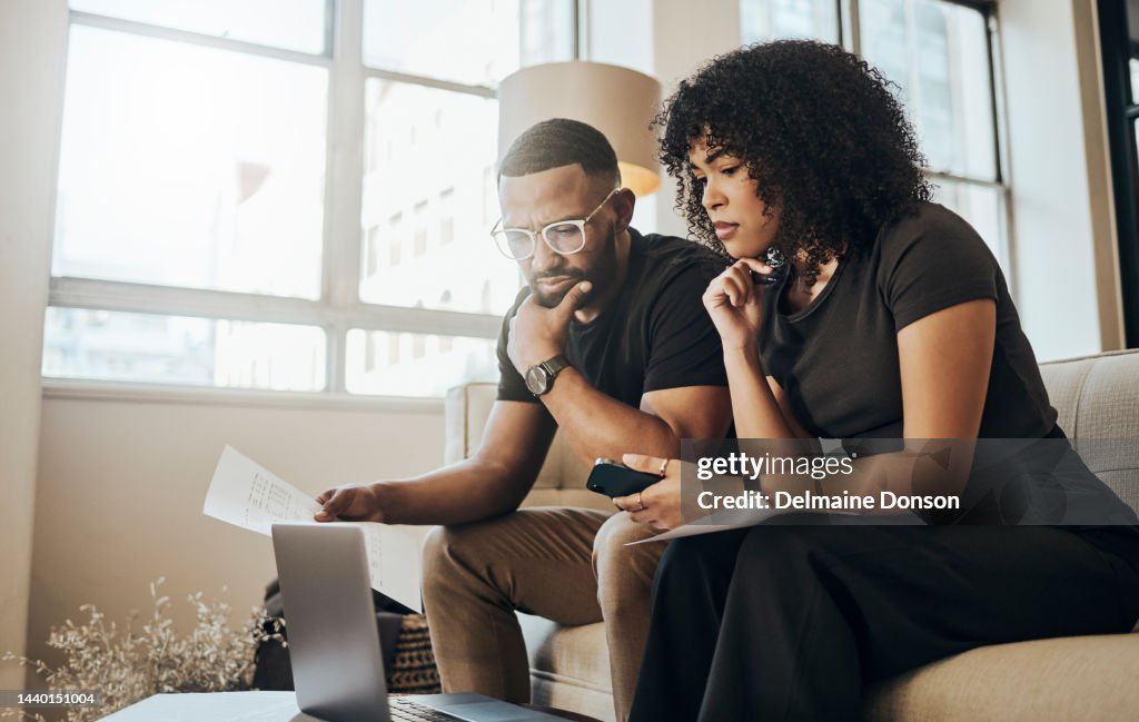 Laptop, paper and couple with mortgage, bills or loans doing financial calculations together at home. Computer, finance and young people from Puerto Rico paying debt with online internet banking.