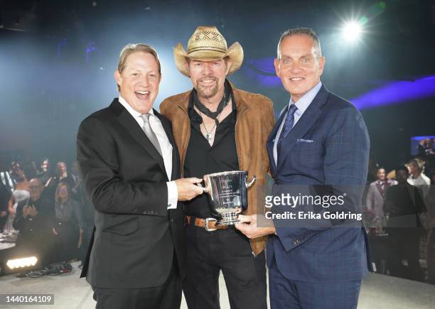 Toby Keith accepts an award onstage from BMI VP of Creative Nashville, Clay Bradley and president and CEO of BMI Mike O'Neill for the 2022 BMI...