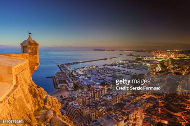 scenic view of alicante city from day to night - alicante province stock pictures, royalty-free photos & images