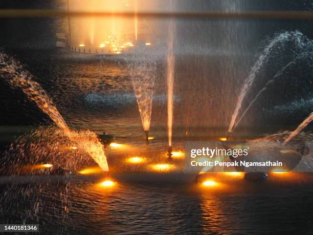 fountain yellow light - squirt stockfoto's en -beelden