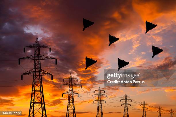 attack of kamikaze drones on the power grid. drones over power lines - kamikaze photos et images de collection