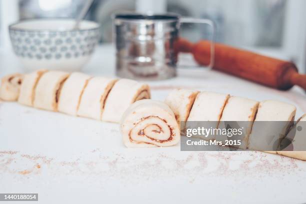 close-up of homemade cinnamon rolls being prepared on a kitchen worktop - cinnamon bun stock pictures, royalty-free photos & images