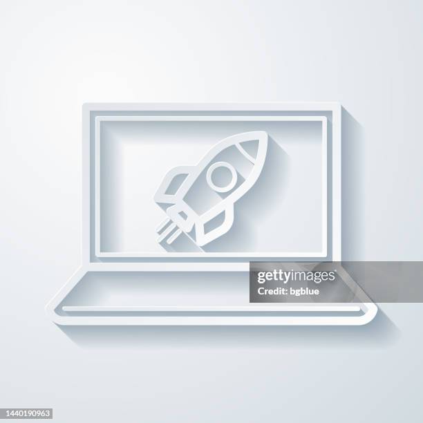 laptop with rocket. icon with paper cut effect on blank background - missile launch stock illustrations