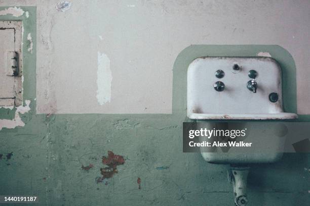 vintage sink mounted on a damaged white and green wall, san francisco. - bathroom sink stock-fotos und bilder