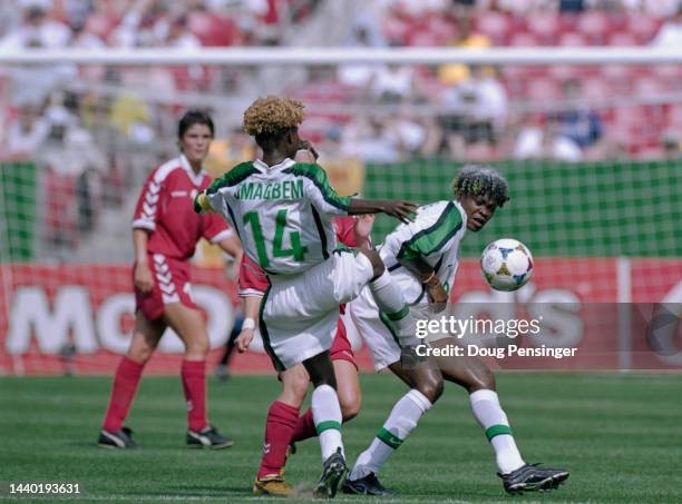 Mercy Akide and Florence Omagbemi for Nigeria are challenged for the football by Christina Petersen, Midfield for Denmark during the Group A match of...