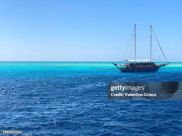 sinai - egipt - sharm el sheik -  ras mohammed national park tourist boat similar to pirate boat on a blue and transparent sea - navy blue photos et images de collection
