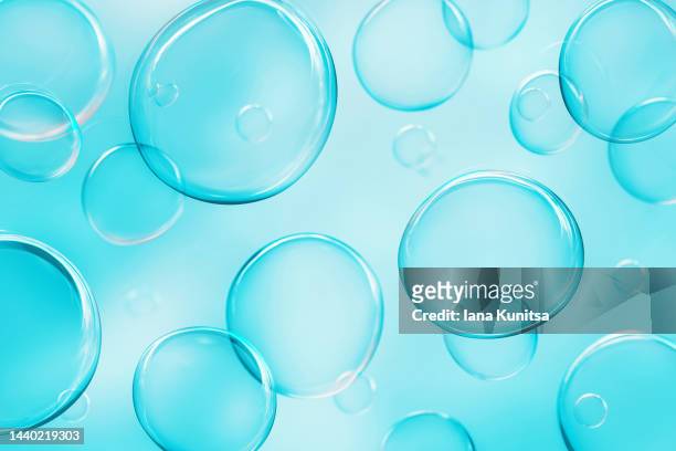 bright transparent soap bubbles on blue background. beautiful 3d pattern. festive and harmony backdrop. - schaumstoff stock-fotos und bilder