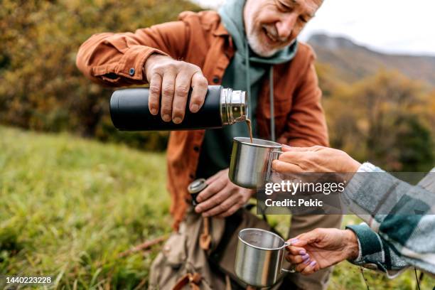 senior hikers having a hot tea while taking a break - flask stock pictures, royalty-free photos & images