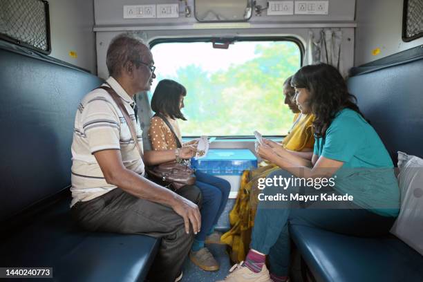 three generation family playing cards while traveling by train - family trip in laws stock pictures, royalty-free photos & images