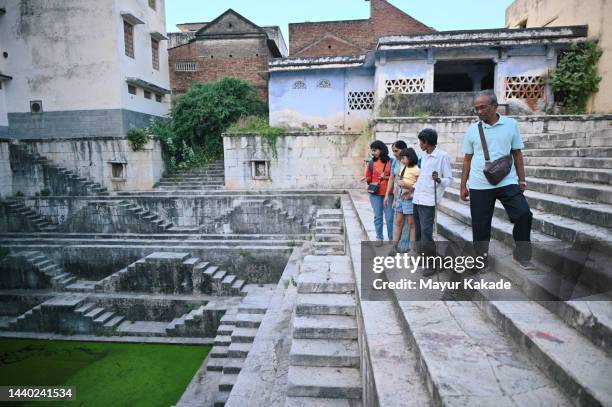 family tourists visiting a step well in rajasthan with a guide - indian tour guide stock pictures, royalty-free photos & images