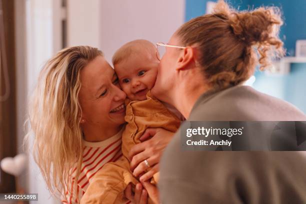 two mothers kissing their baby girl - photos of lesbians kissing stock pictures, royalty-free photos & images
