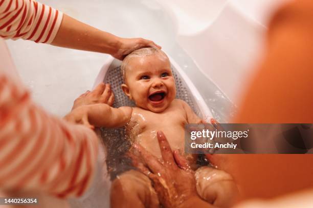 female gay couple bathing baby in bathtub - cute lesbian couples 個照片及圖片檔