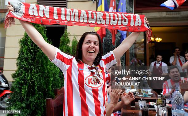 Supporters of Atletico Madrid celebrate in front of a restaurant in Bucharest's old city center on May 8, 2012 on the eve of the UEFA Europa League...