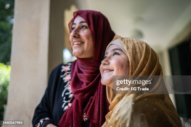 happy mother and daughter looking away in the balcony - traditional clothing stock pictures, royalty-free photos & images