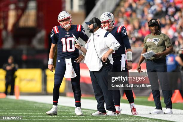 Mac Jones of the New England Patriots talks with senior football advisor Matt Patricia during a game against the Indianapolis Colts at Gillette...