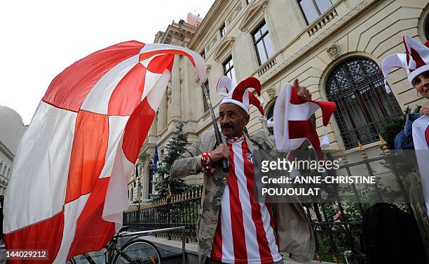 Supporter of Atletico Madrid waves a flag as he walks through Bucharest's old city center on May 8, 2012 on the eve of the UEFA Europa League final...