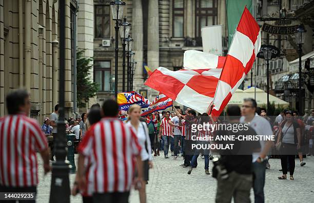 Supporters of Atletico Madrid wave a flag as they walk through Bucharest's old city center on May 8, 2012 on the eve of the UEFA Europa League final...