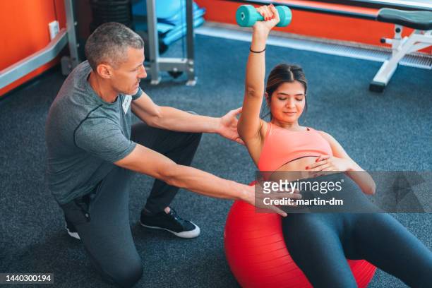 gym-training mit personal trainer - bubble chair stock-fotos und bilder