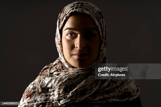 portrait of young muslim woman wearing hijab with black background - voile religieux photos et images de collection