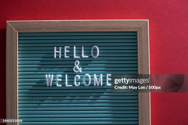 hello and welcome text on letter board against red background,malaysia - welcome stock-fotos und bilder