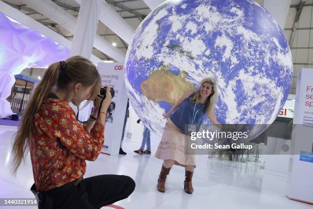 Conference participants photograph one another under a model of Planet Earth during the UNFCCC COP27 climate conference on November 09, 2022 in Sharm...