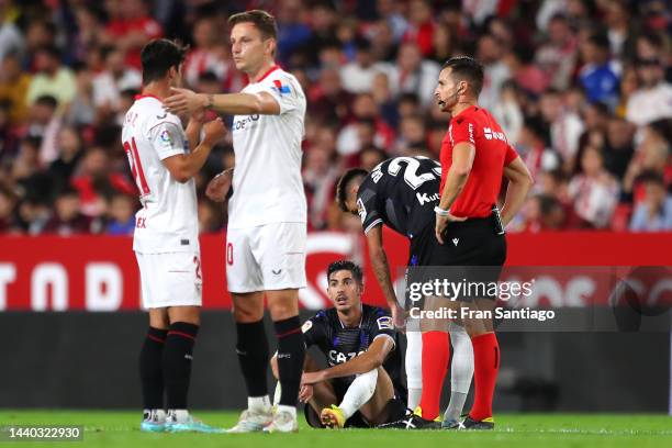 Carlos Fernandez of Real Sociedad goes down injured while being checked on by teammate Brais Mendez during the LaLiga Santander match between Sevilla...