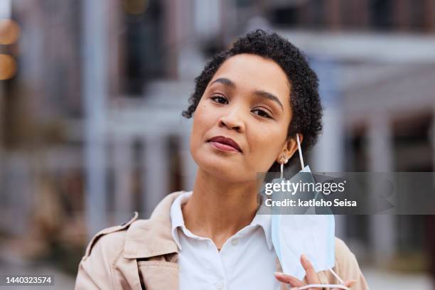 woman in city, remove face mask at end of covid disease infection and health policy change portrait. corona virus quarantine is over, vaccine safety in outdoor urban air or protection from pollution - air pollution mask stockfoto's en -beelden