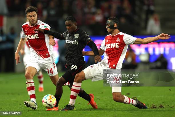 Jonas Hector and Ellyes Skhiri of 1.FC Koln battles for possession with Jeremie Frimpong of Bayer 04 Leverkusen during the Bundesliga match between...
