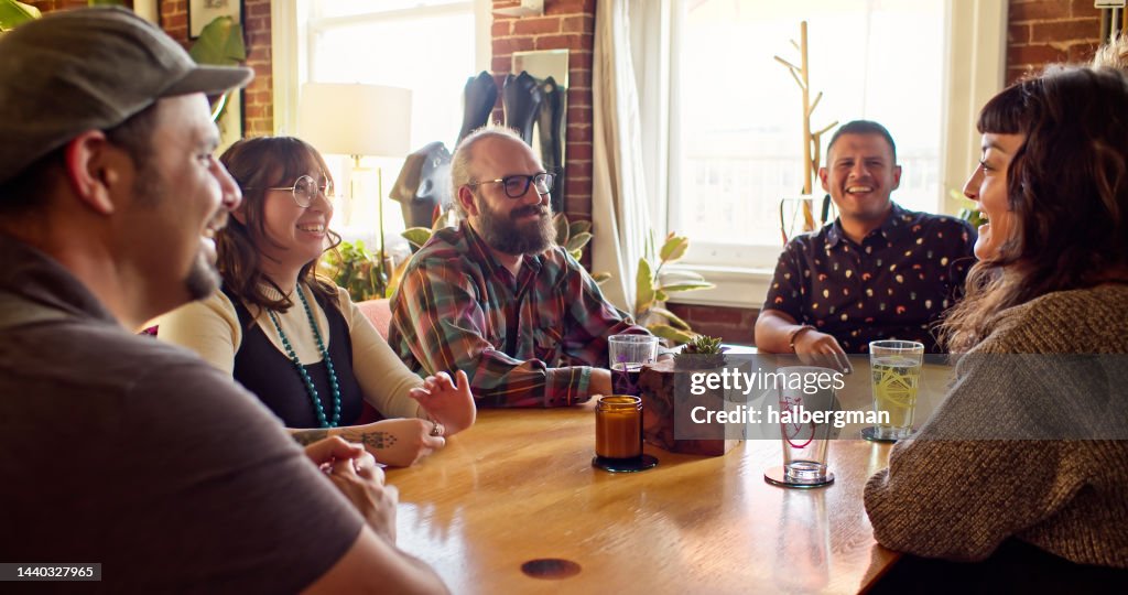 Table Look Friend Friends Laughing And Chatting Around Dining Table High-Res Stock Photo ...