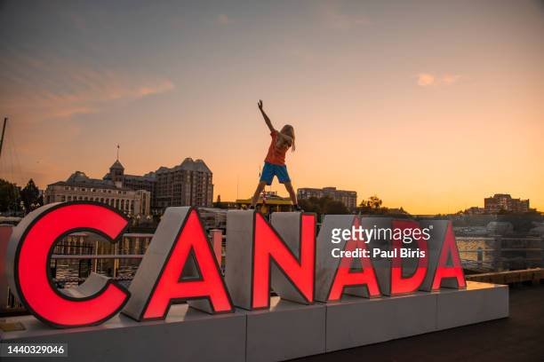 young boy playing over red 3dcanada sign in victoria, british columbia, canada - canada day people stock pictures, royalty-free photos & images
