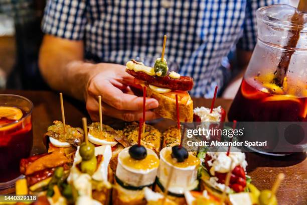 man eating pincho tapas with sangria at the bar, barcelona, spain - barcelona tapas stock pictures, royalty-free photos & images