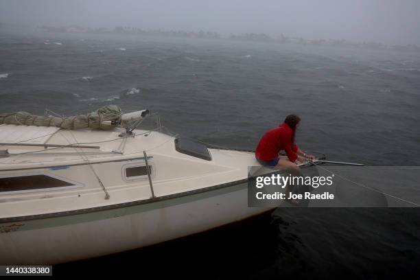 Kelly McFadden, works on securing a sailboat next to the seawall after it broke away from its anchor due to the high winds and surf from the...