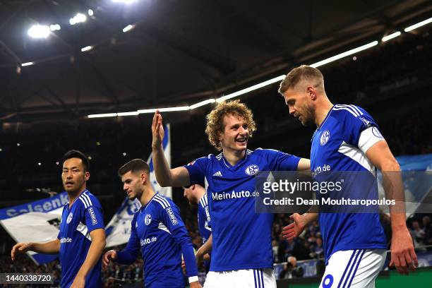 Simon Terodde of FC Schalke 04 celebrates with teammates after scoring their team's first goal during the Bundesliga match between FC Schalke 04 and...