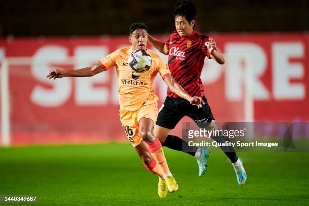 Kang-In Lee of RCD Mallorca competes for the ball with Nahuel Molina of Atletico de Madrid during the LaLiga Santander match between RCD Mallorca and...