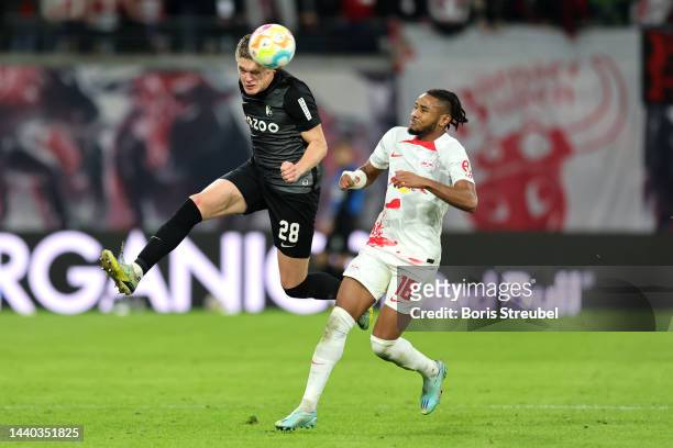 Matthias Ginter of SC Freiburg battles for possession with Christopher Nkunku of RB Leipzig during the Bundesliga match between RB Leipzig and...
