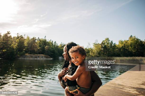portrait of happy boy in mother arms during vacation - incidental people stock pictures, royalty-free photos & images