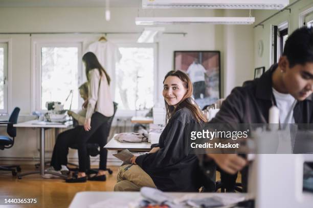 portrait of smiling female fashion designer sitting at workshop - green economy stock pictures, royalty-free photos & images