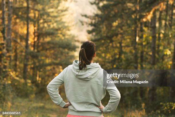 female athlete catching breath after jogging - hooded top stock pictures, royalty-free photos & images