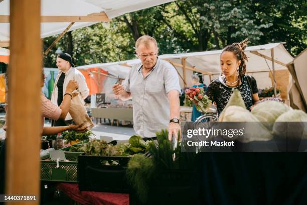 customers buying organic vegetables from market - small group of people outdoors food stock pictures, royalty-free photos & images