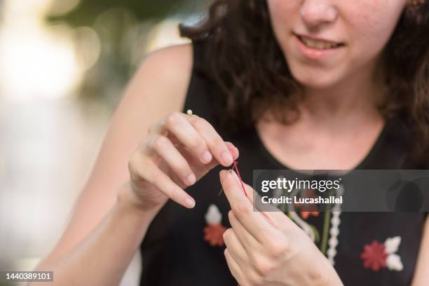 young girl sewing an embroidery in a square - pin up girl stockfoto's en -beelden