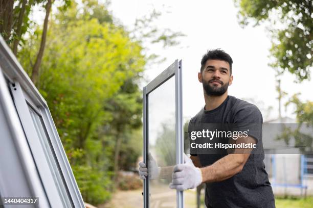 construction worker carrying a panel of a sliding door - installing 個照片及圖片檔