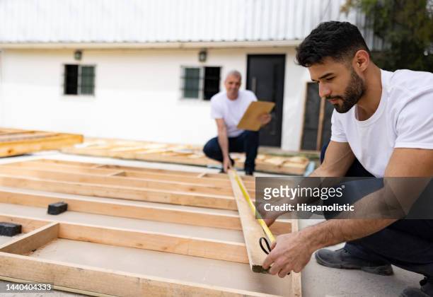 men volunteering to build a house and taking some measurements - habitat for humanity stock pictures, royalty-free photos & images