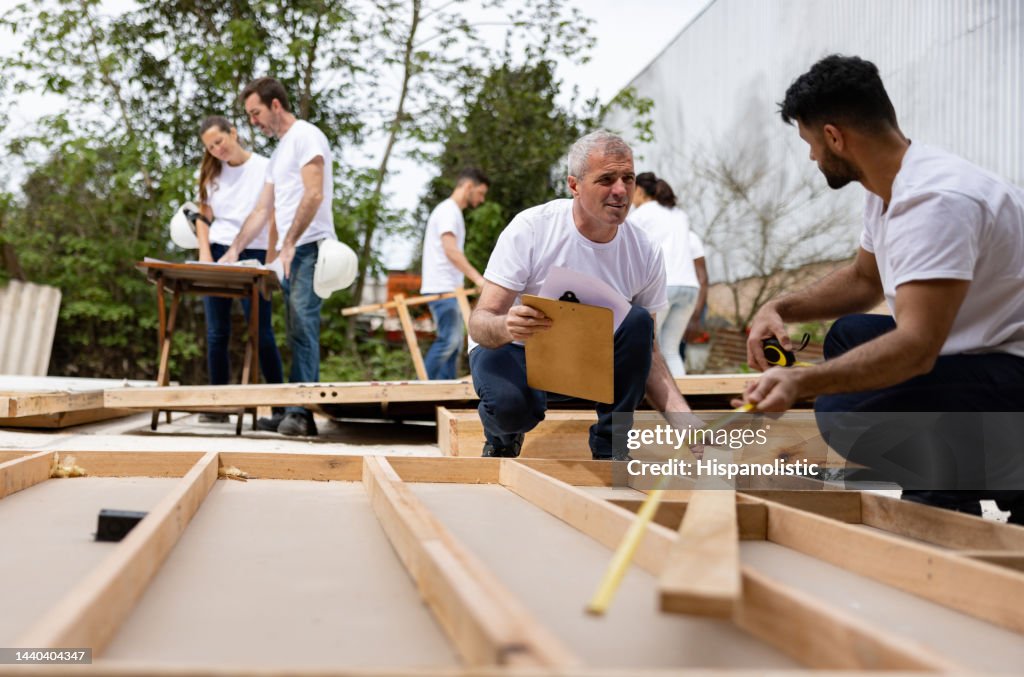 Group Of People Volunteering To Build A House High-Res Stock Photo