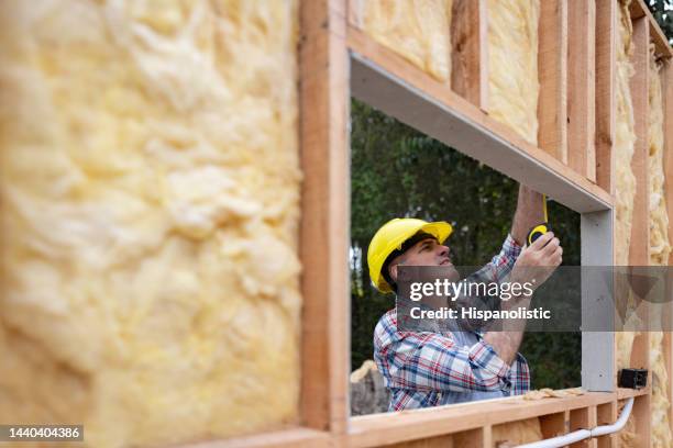 家を建てながら測定する建設作業員 - トレーラハウス ストックフォトと画像