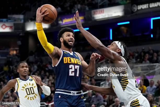 Jamal Murray of the Denver Nuggets attempts a shot while being guarded by Buddy Hield of the Indiana Pacers in the first quarter at Gainbridge...