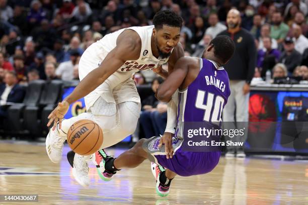 Donovan Mitchell of the Cleveland Cavaliers gets tangled with Harrison Barnes of the Sacramento Kings in the second half at Golden 1 Center on...