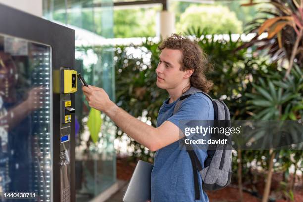 person making a digital payment at a vending machine - verkoopautomaat stockfoto's en -beelden