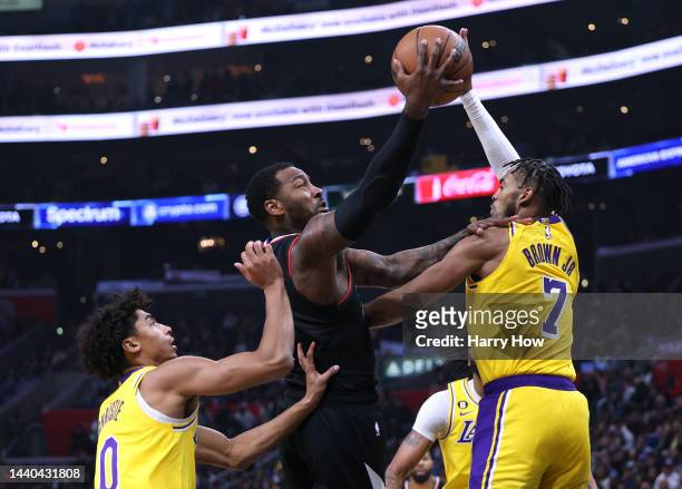 John Wall of the LA Clippers attempts a layup between Max Christie and Troy Brown Jr. #7 of the Los Angeles Lakers during a 114-101 Clippers win at...