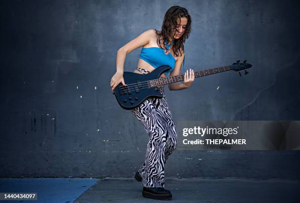 joven rebelde tocando la guitarra eléctrica - girl playing bass guitar fotografías e imágenes de stock